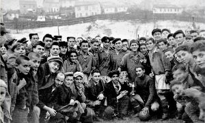 Fk Prvi Partizan na stadionu u Begluku tokom pedesetih godina 20. veka sa navijačima; Asan Dudić prvi u dresu s leva