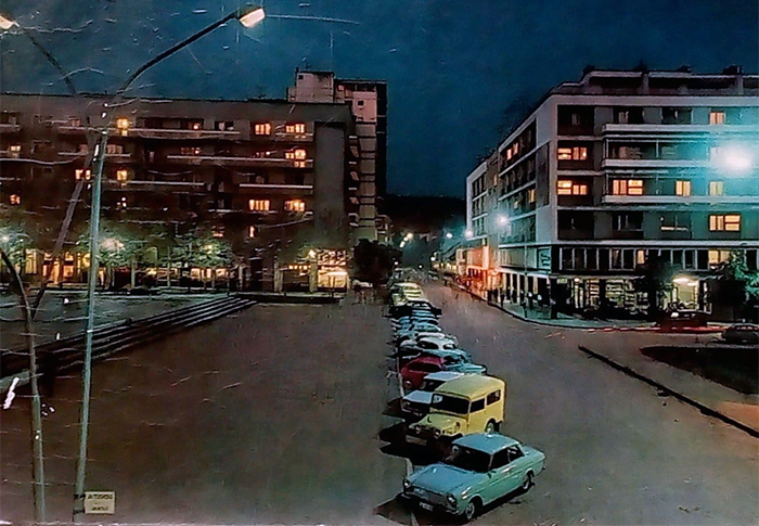 Razglednica Trg noću 1970. godine, “Autotehna” sva u staklu blista sa izloženim luksuznim automobilom